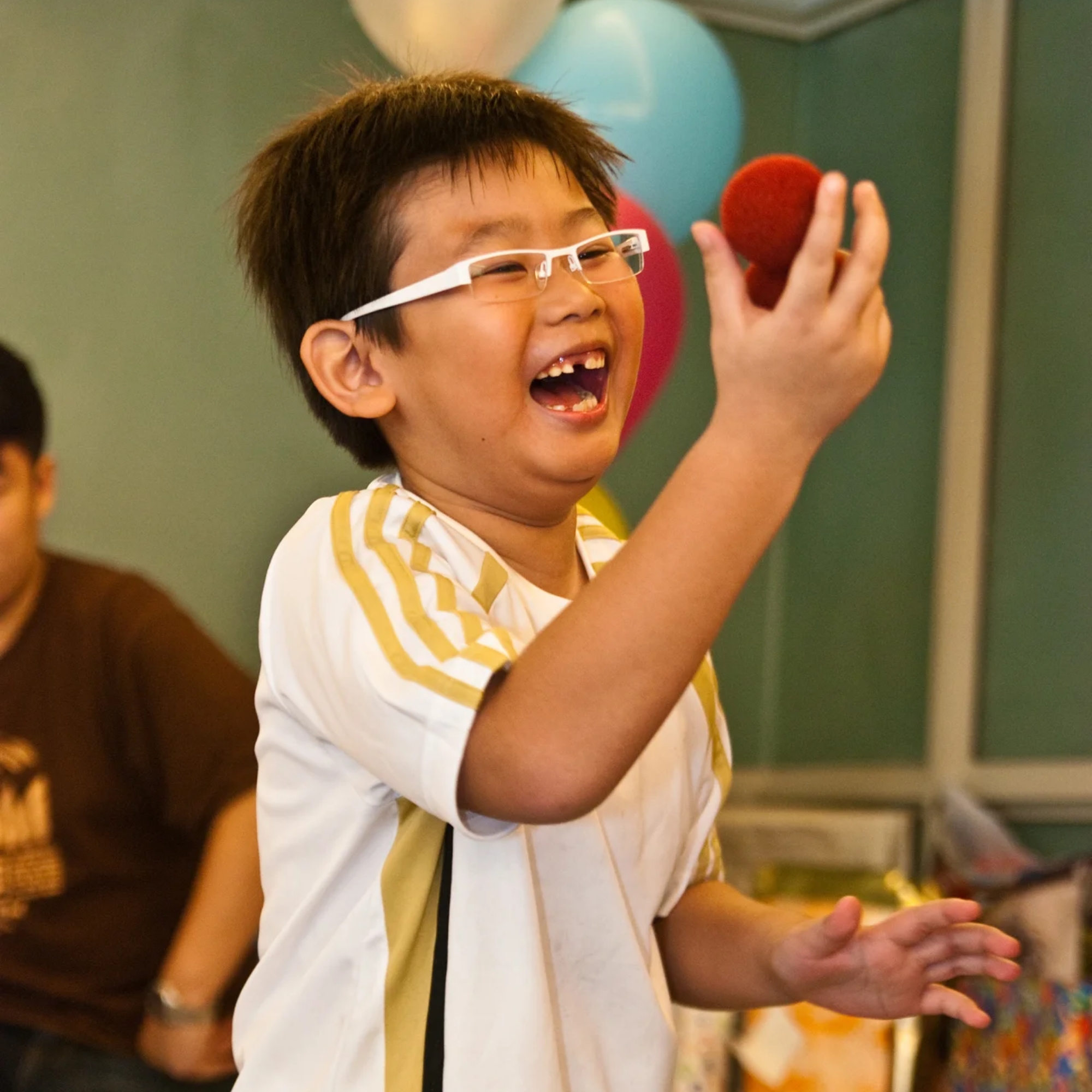 Child laughing during a birthday magic trick