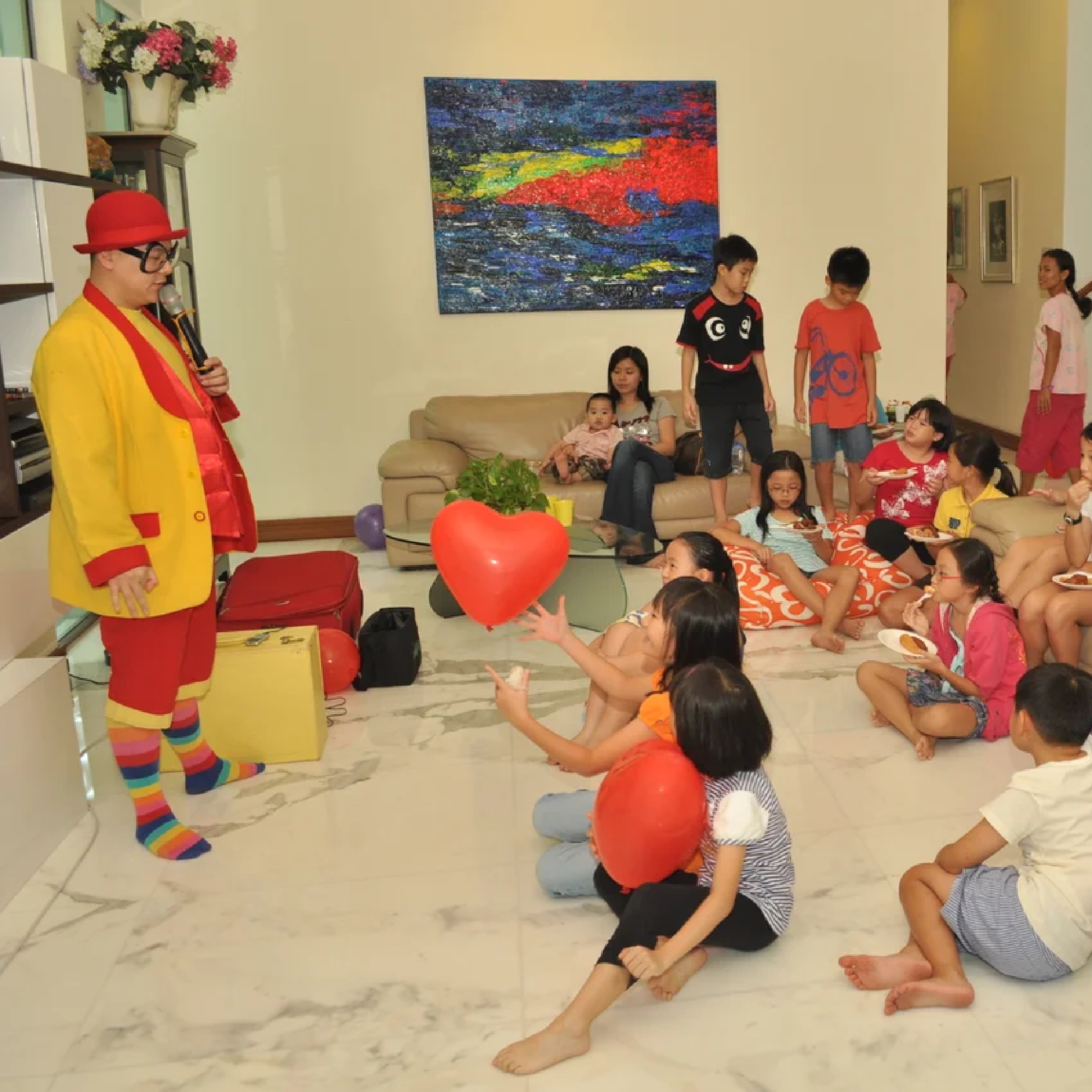 Children reaching for a balloon during a party